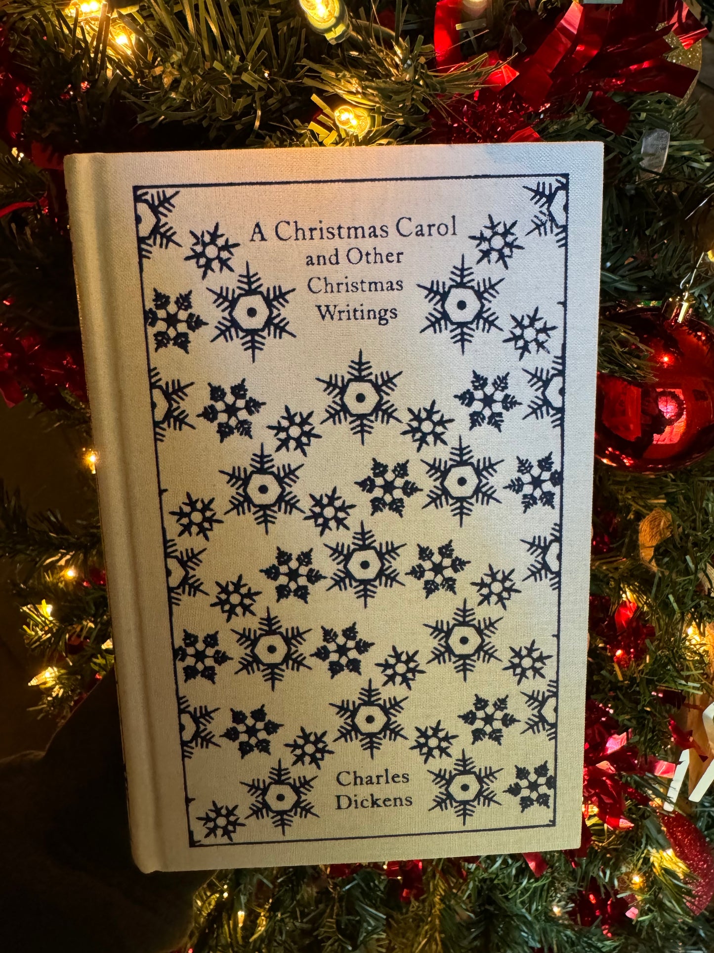 A book cover of 'A Christmas Carol' by Charles Dickens, featuring a decorative pattern with snowflakes and floral motifs.