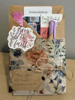 Decorative card with floral design, text, and stationery items on a stand.