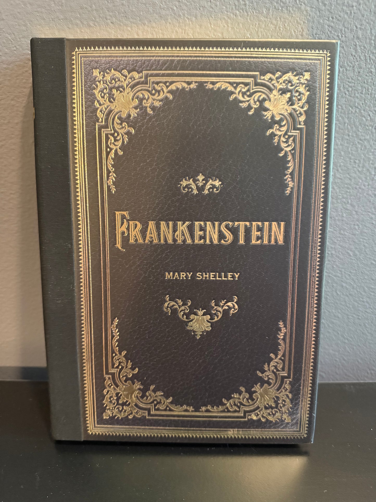 Decorative book cover of 'Frankenstein' by Mary Shelley on a plain background