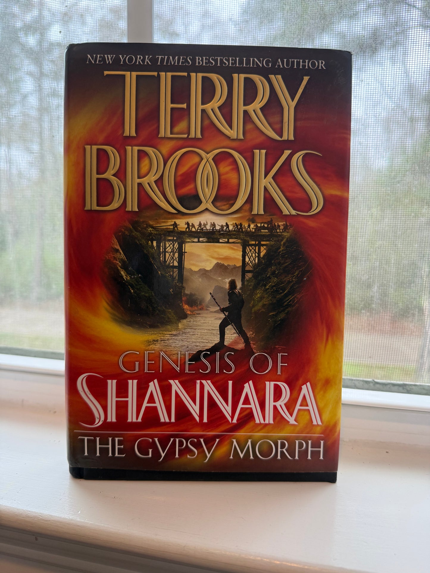 Book titled 'Genesis of Shannara: The Gypsy Morph' by Terry Brooks on a surface with a blurred background.