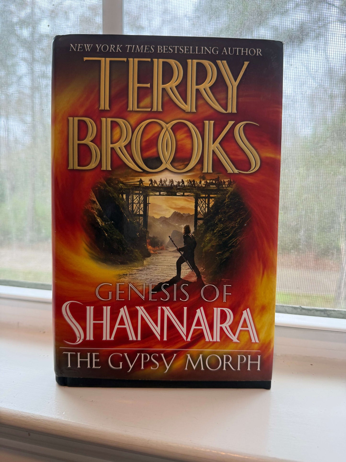 Book titled 'Genesis of Shannara: The Gypsy Morph' by Terry Brooks on a surface with a blurred background.