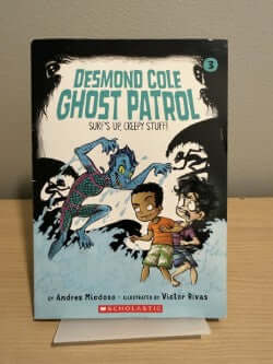 Book titled 'Ghost Patrol' by Desmond Cole on a stand with a gray background