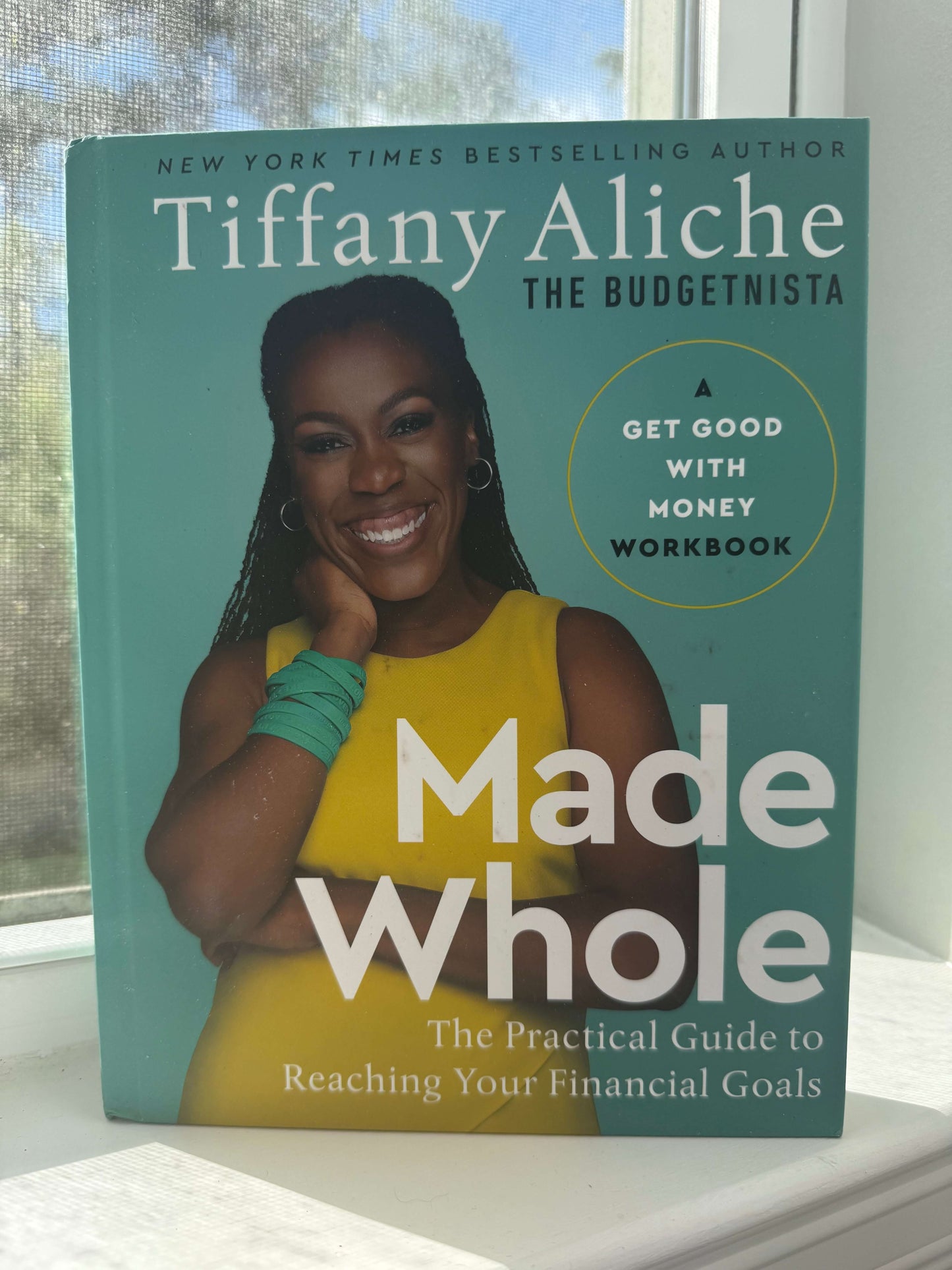 Book titled 'Made Whole' by Tiffany Aliche on a surface with a blurred background