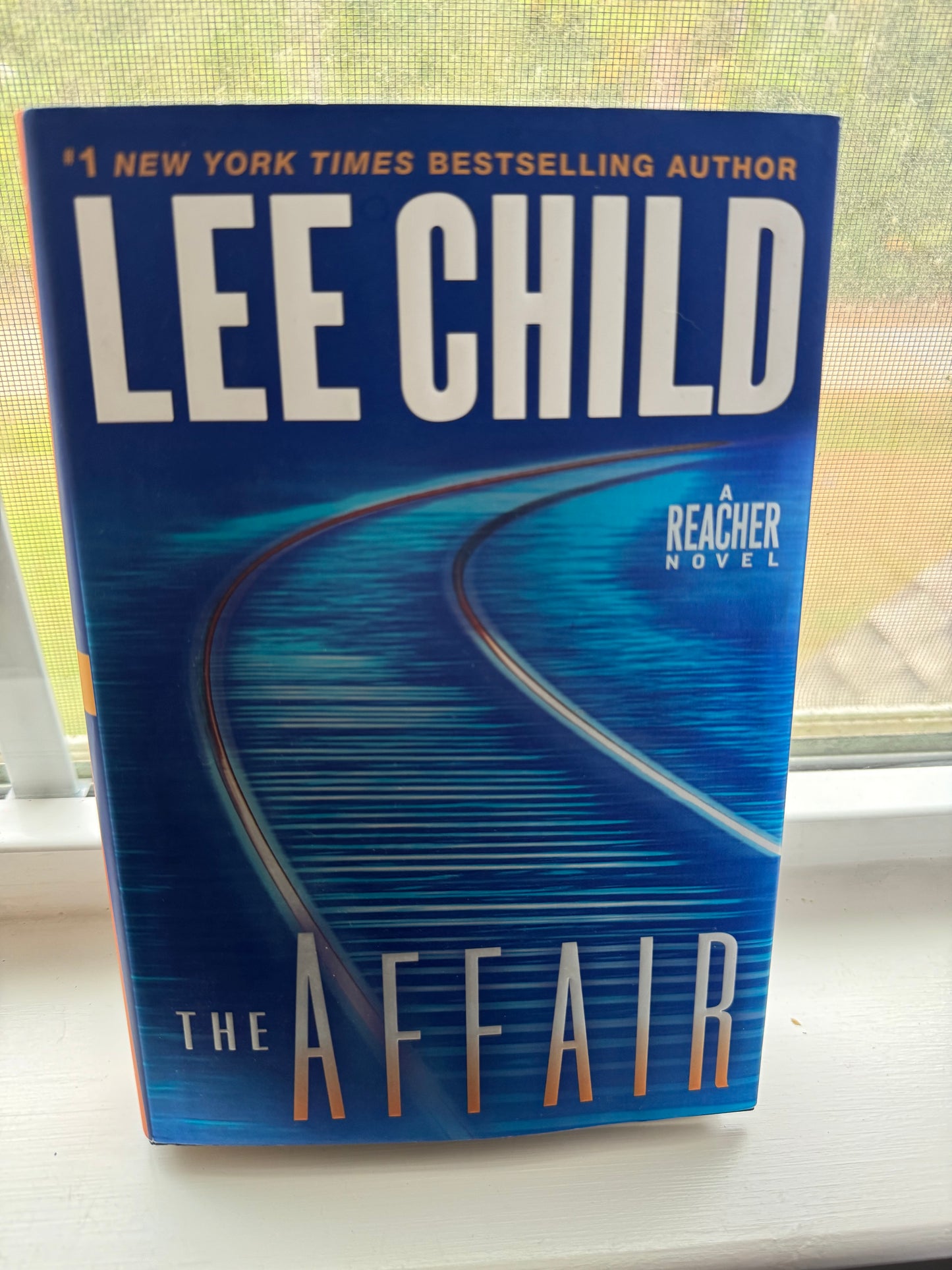 Book titled 'The Affair' by Lee Child on a reflective surface