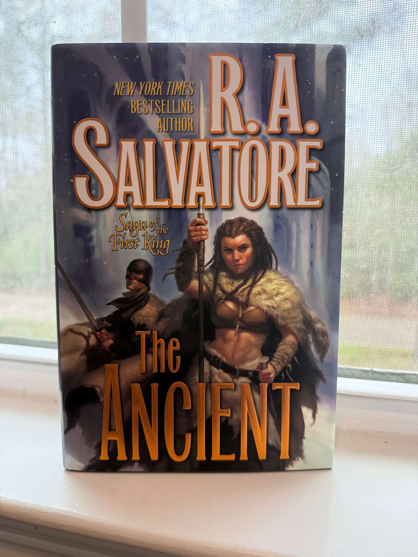 Book titled 'The Ancient' by R.A. Salvatore on a windowsill.