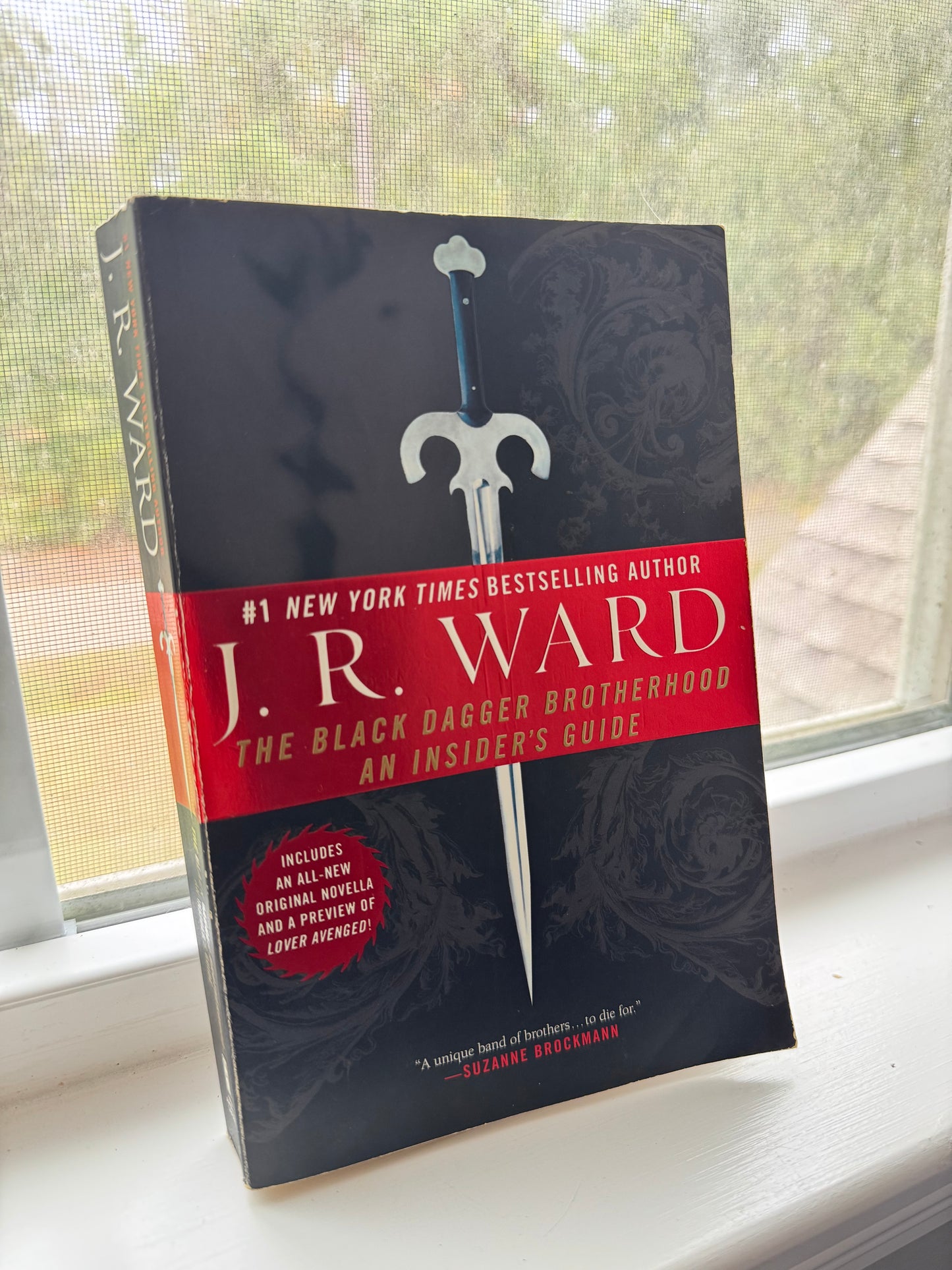 Book titled 'The Black Dagger Chronicles' by J.R. Ward on a surface with a blurred background