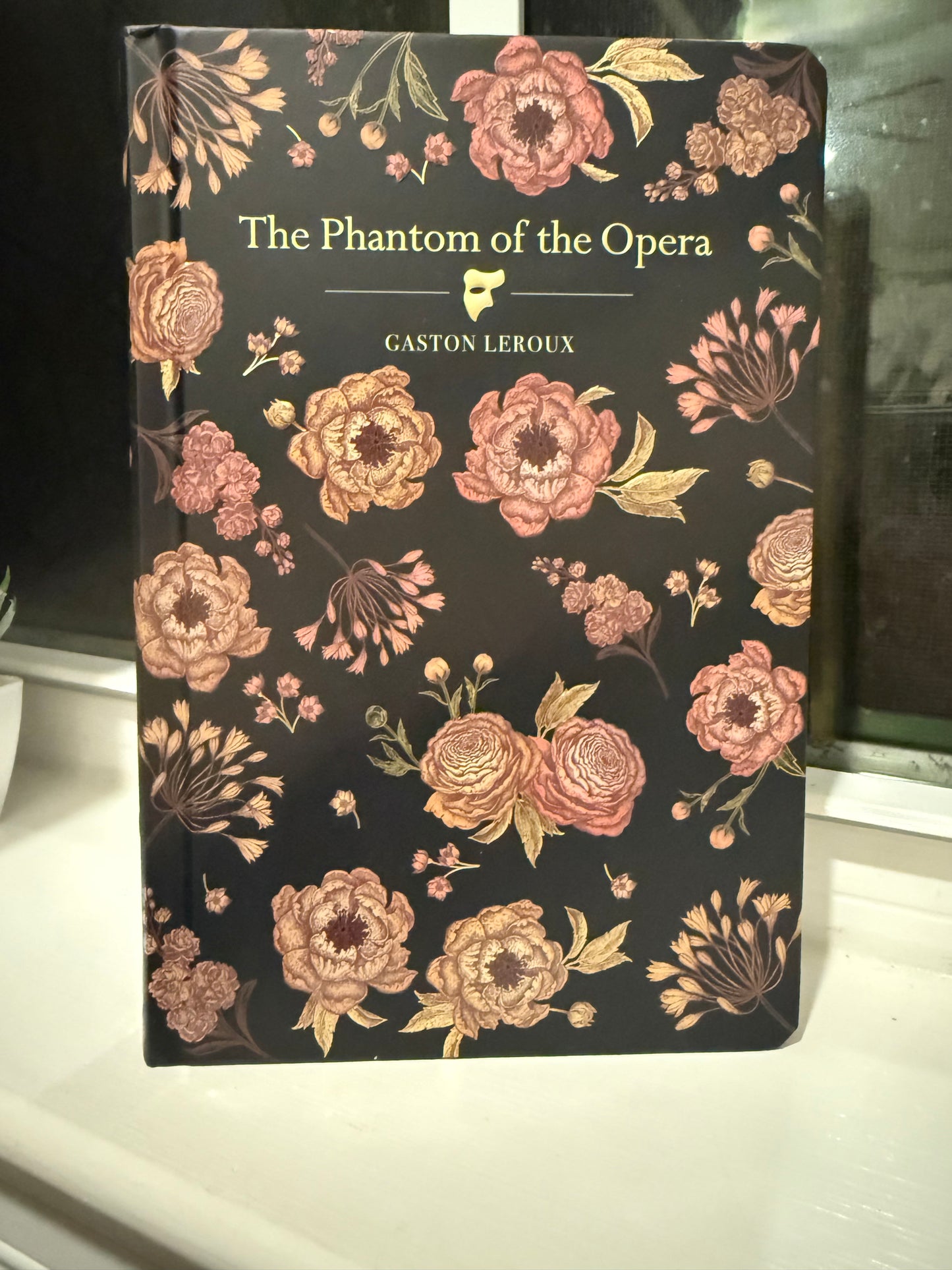 Book cover with floral design and text 'The Phantom of the Opera' by Gaston Leroux