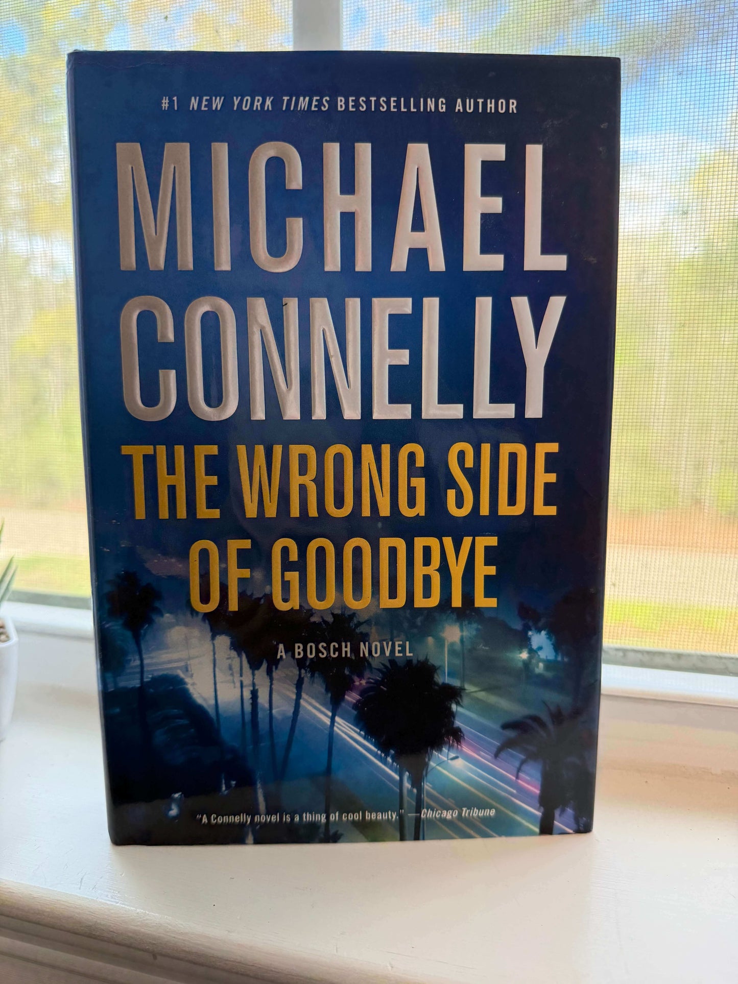 Book titled 'The Wrong Side of Goodbye' by Michael Connelly on a windowsill.