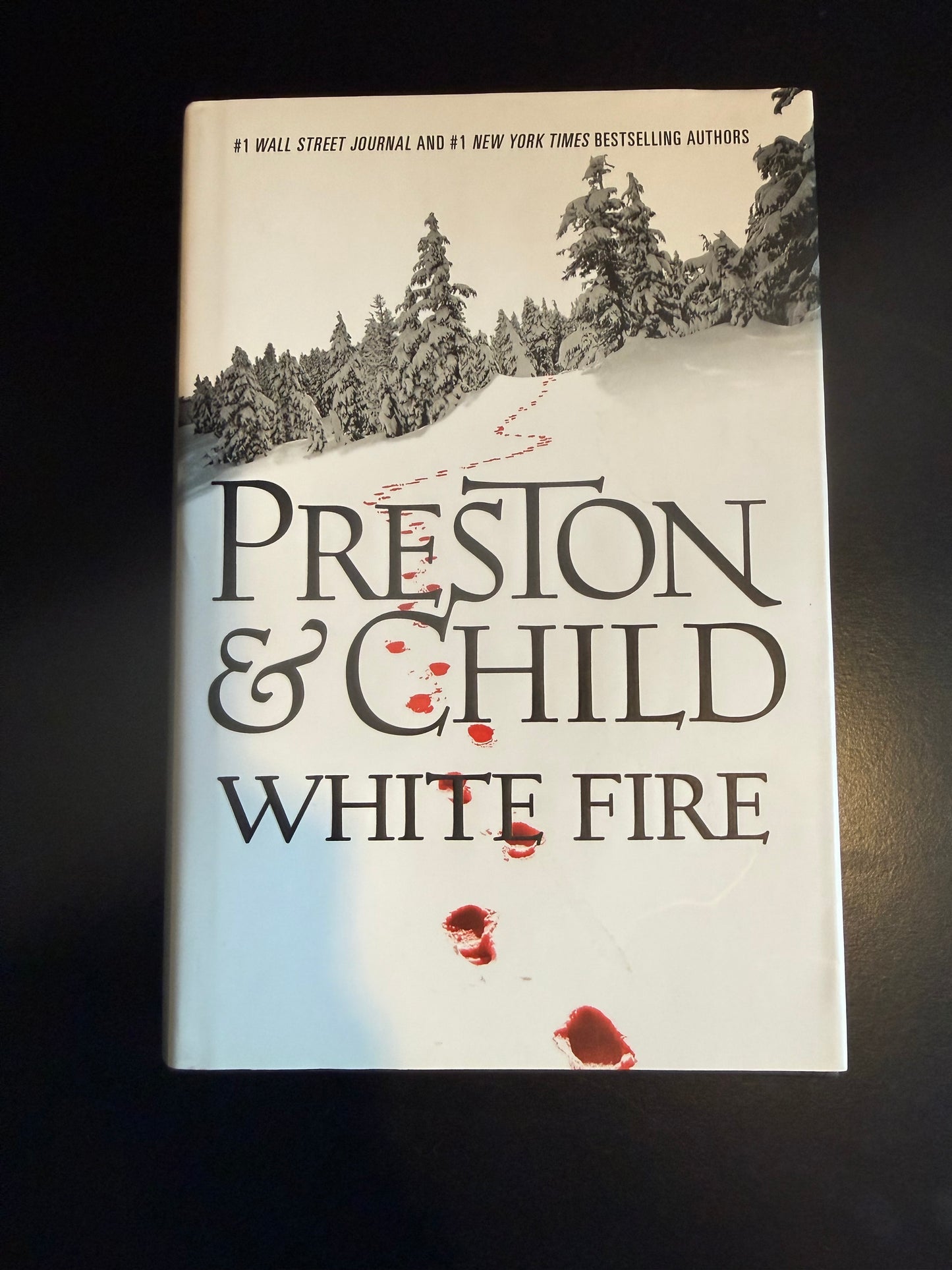 Book titled 'White Fire' by Preston & Child on a dark surface
