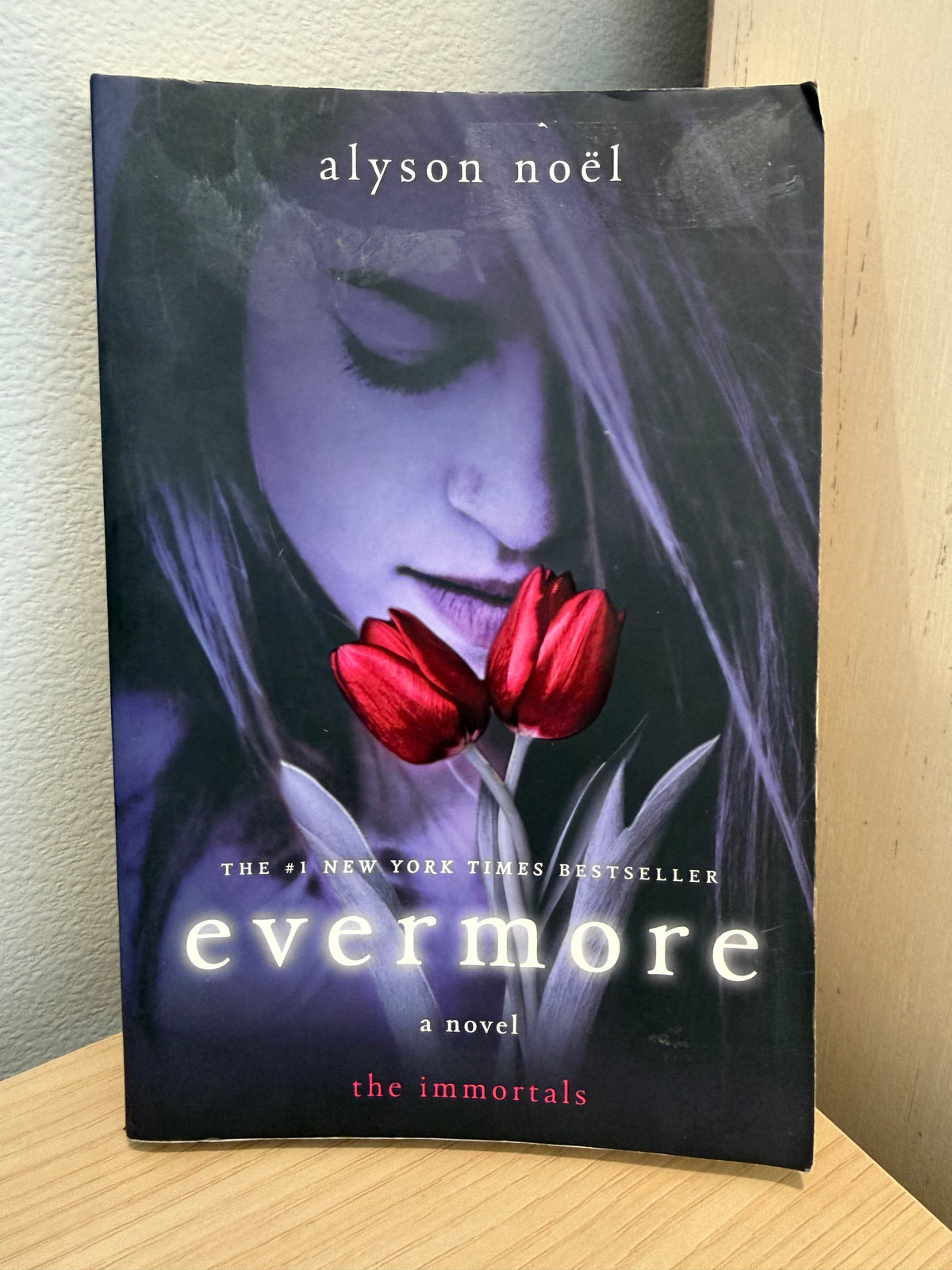 A girl on cover sniffing a rose.