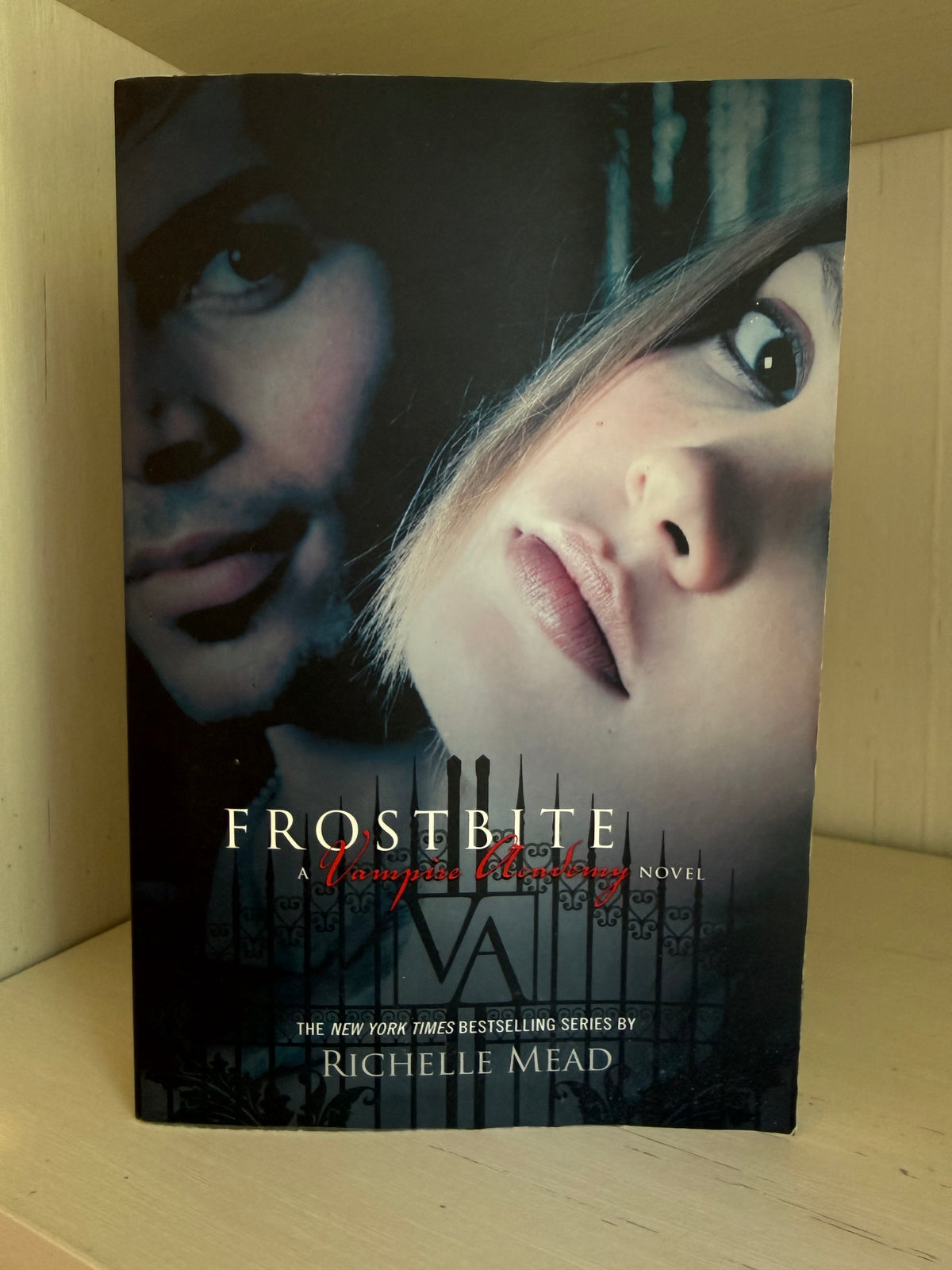 Frostbite: A Vampire Hunting Novel book by Richelle Mead, standing upright on a light wood surface.