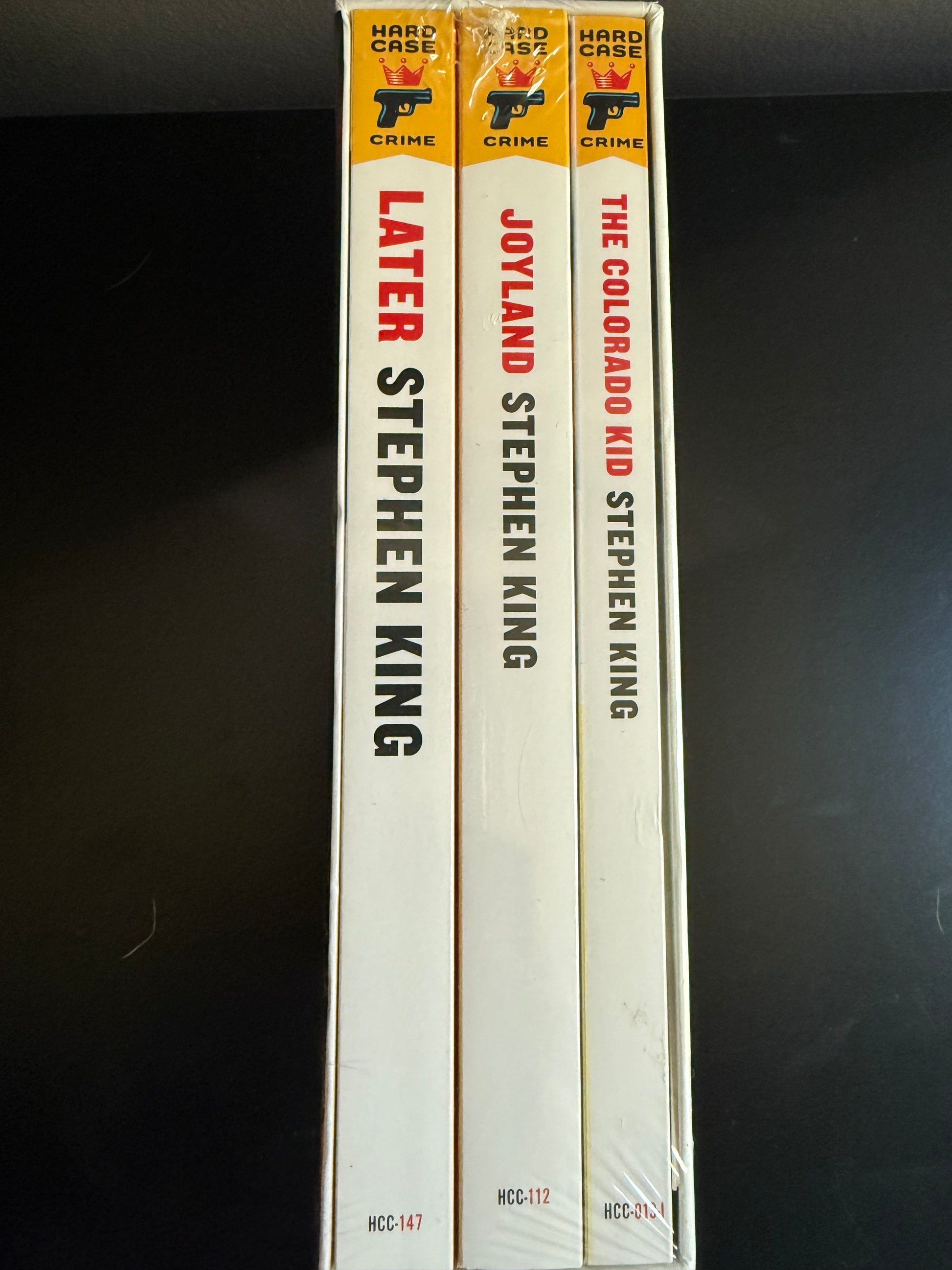 Three books by Stephen King stacked on a dark surface