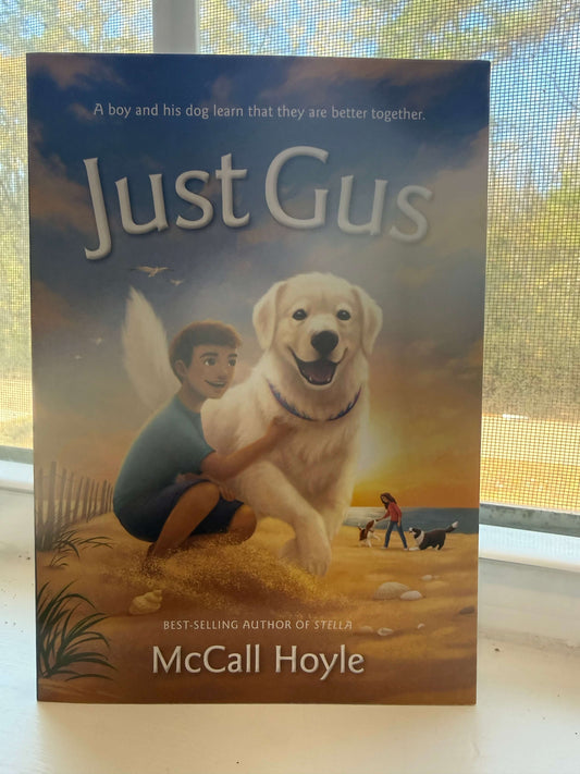 Book cover of 'Just Gus' by McCall Hoyle featuring a boy and his dog on a beach.