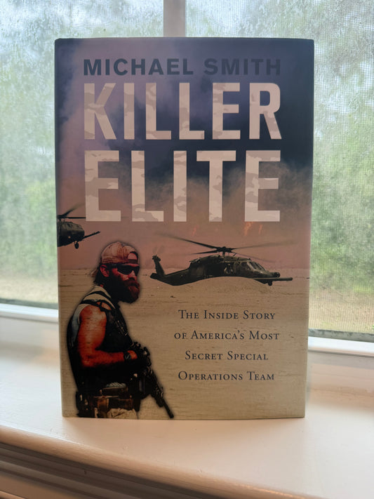 Book titled 'Killer Elite' by Michael Smith on a surface with a blurred background