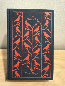 Book titled 'Les Mémérables' with red bird illustrations on a blue background