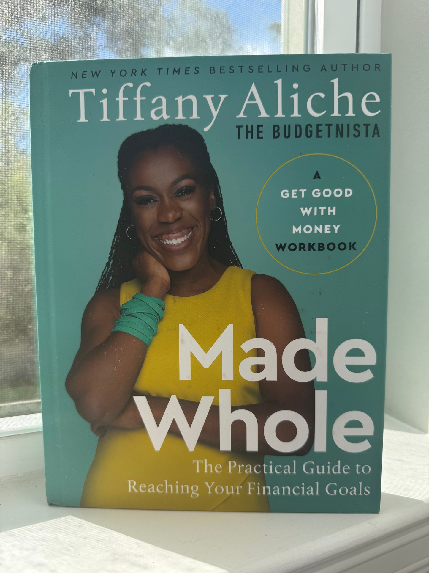 Book titled 'Made Whole' by Tiffany Aliche on a surface with a blurred background
