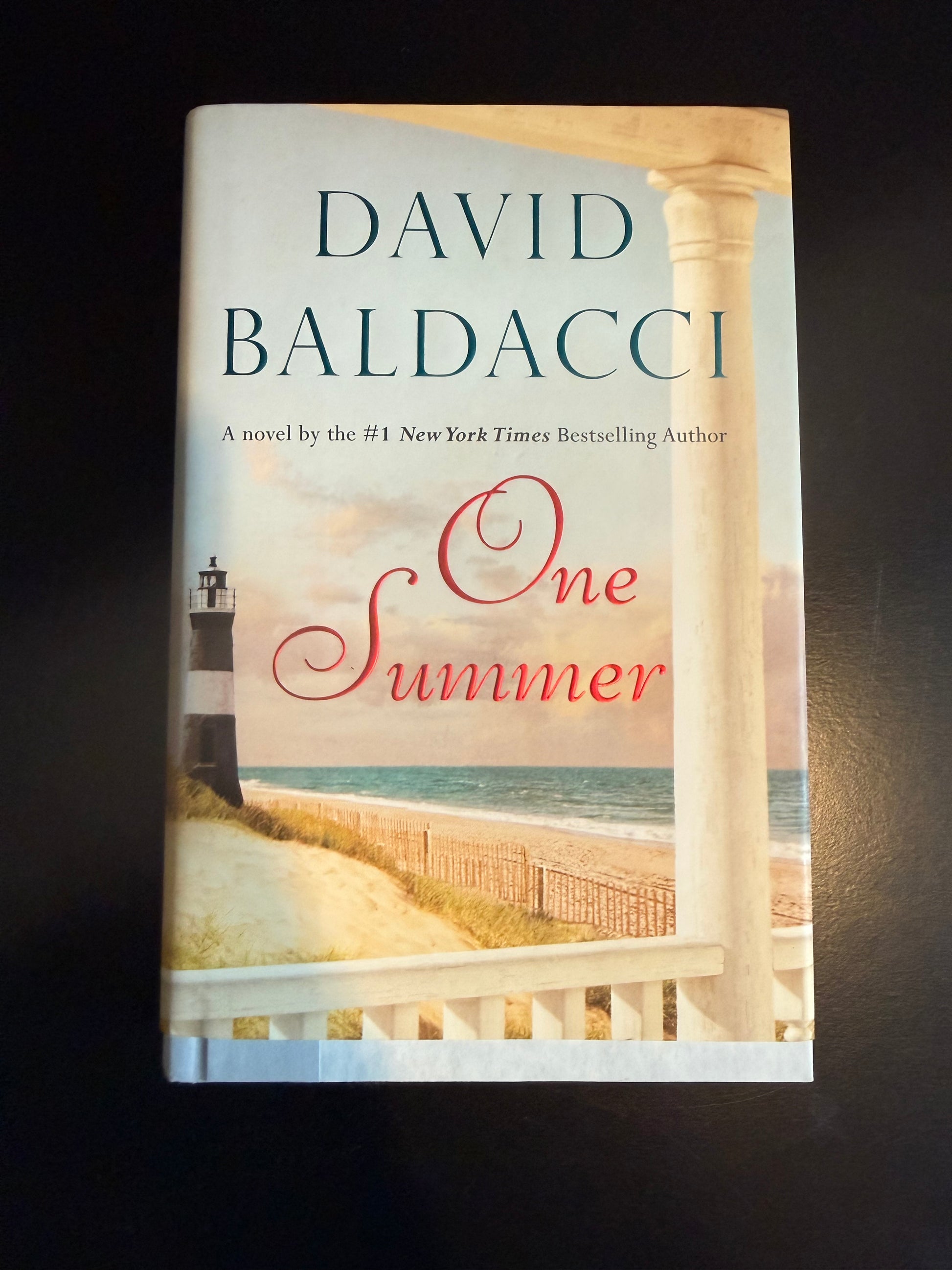 Book titled 'One Summer' by David Baldacci on a dark background
