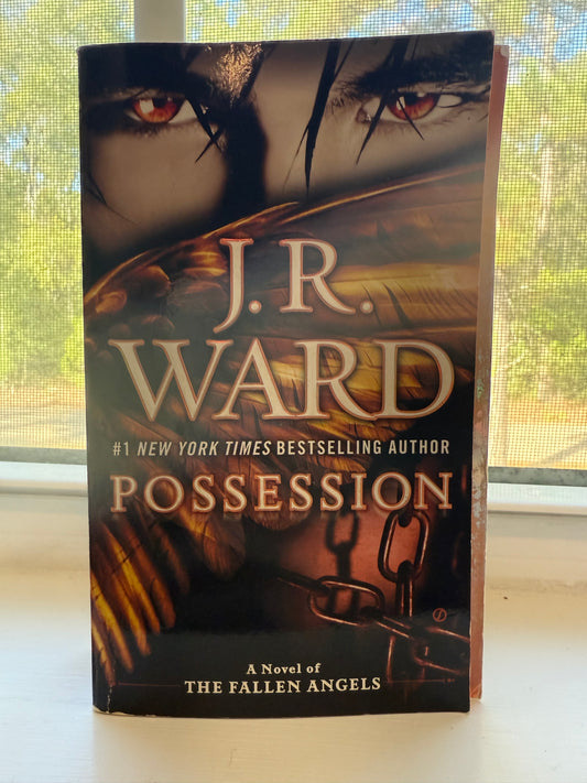 Book titled 'Possession' by J.R. Ward on a surface with a window in the background
