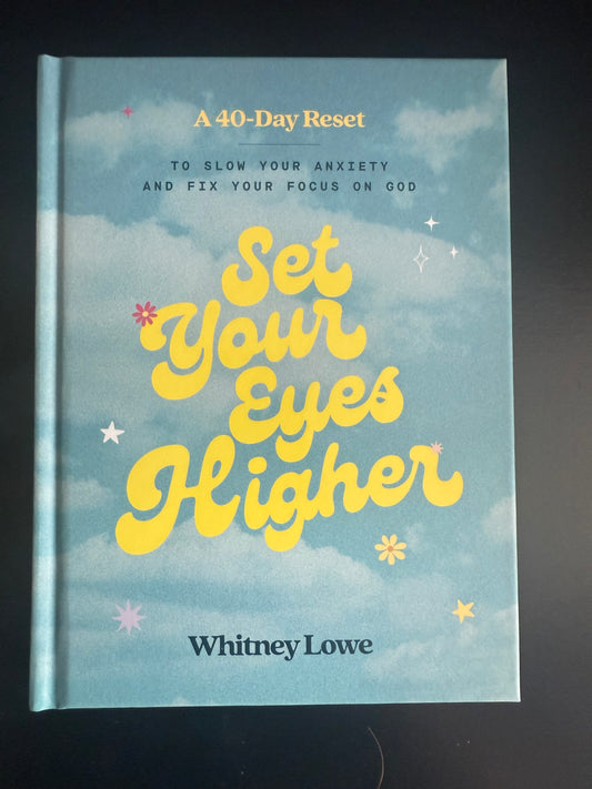 Book cover of 'Set Your Eyes Higher' by Whitney Lowe with a blue background and yellow text.