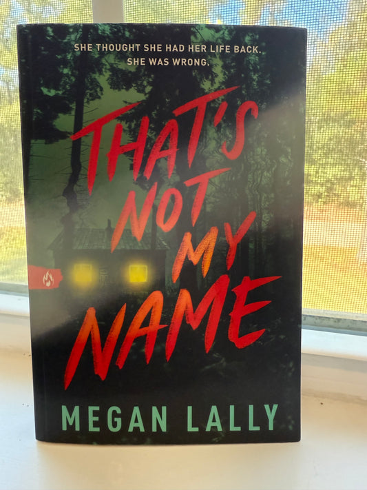 Book cover of 'That's Not My Name' by Megan Lally on a reflective surface
