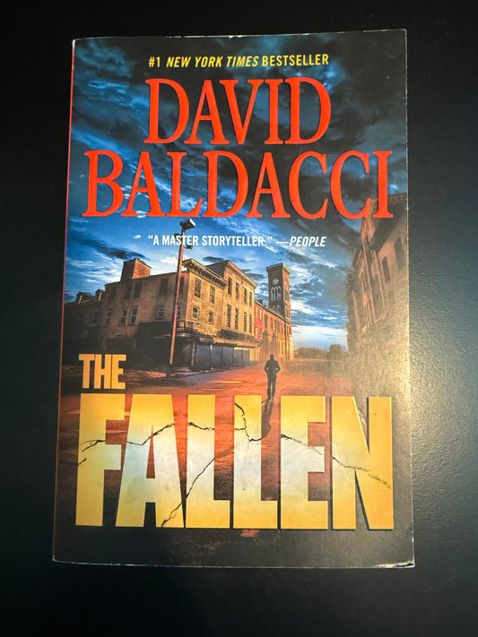 Book cover of 'The Fallen' by David Baldacci on a dark background