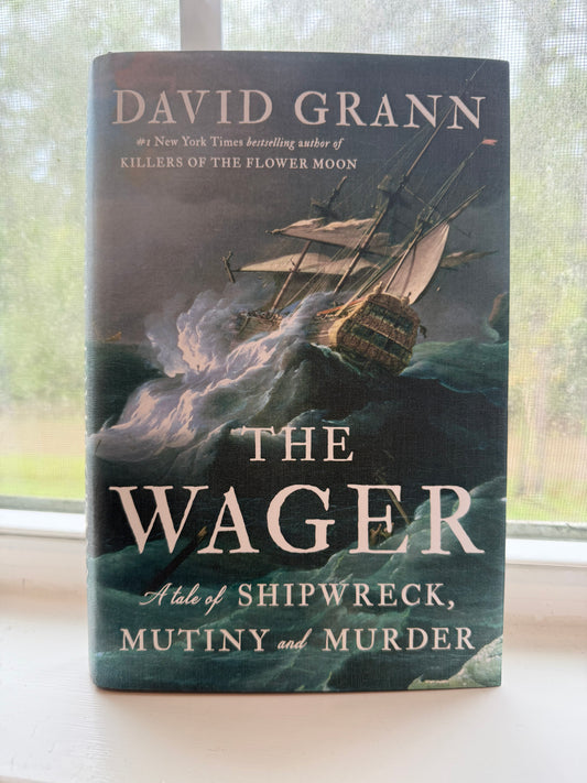 Book titled 'The Wager' by David Grann on a surface with a blurred background
