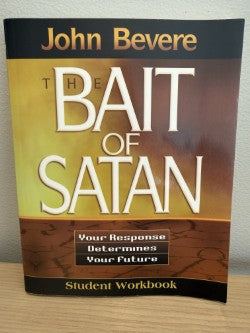 Book titled 'The Bait of Satan' by John Bevere on a wooden surface