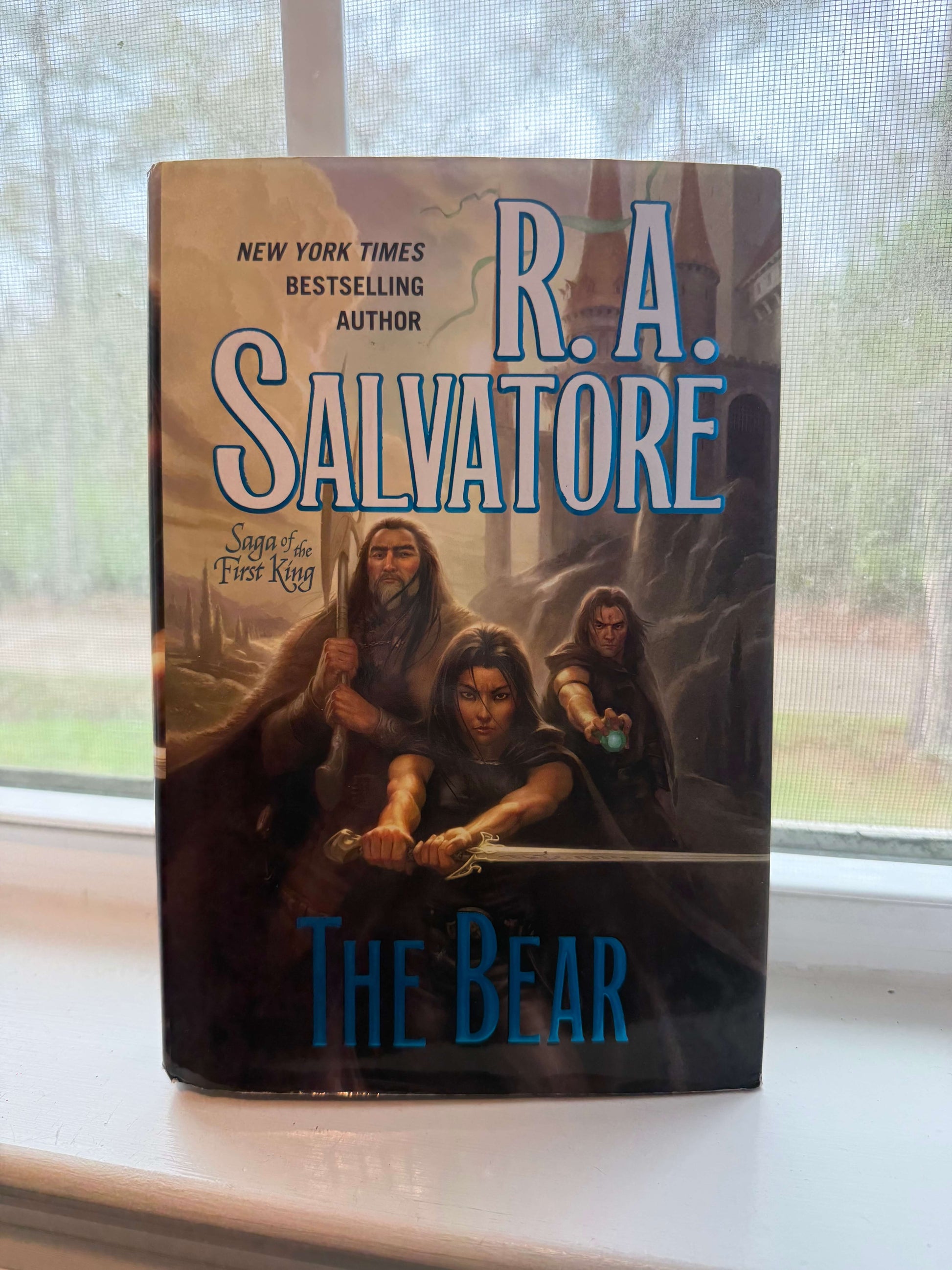 Book titled 'The Bear' by R.A. Salvatore on a windowsill with a blurred outdoor background.