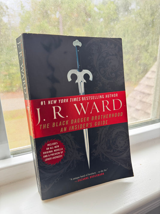 Book titled 'The Black Dagger Chronicles' by J.R. Ward on a surface with a blurred background