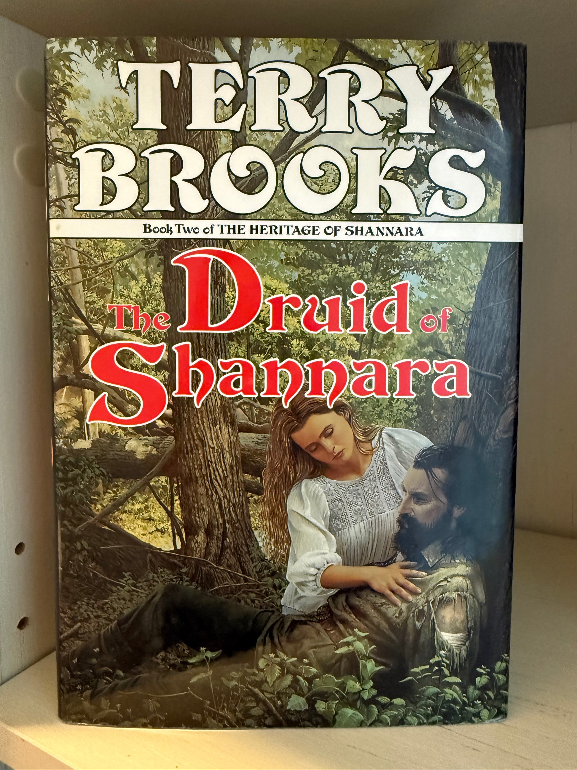 A cover with a woman and man underneath a tree. 