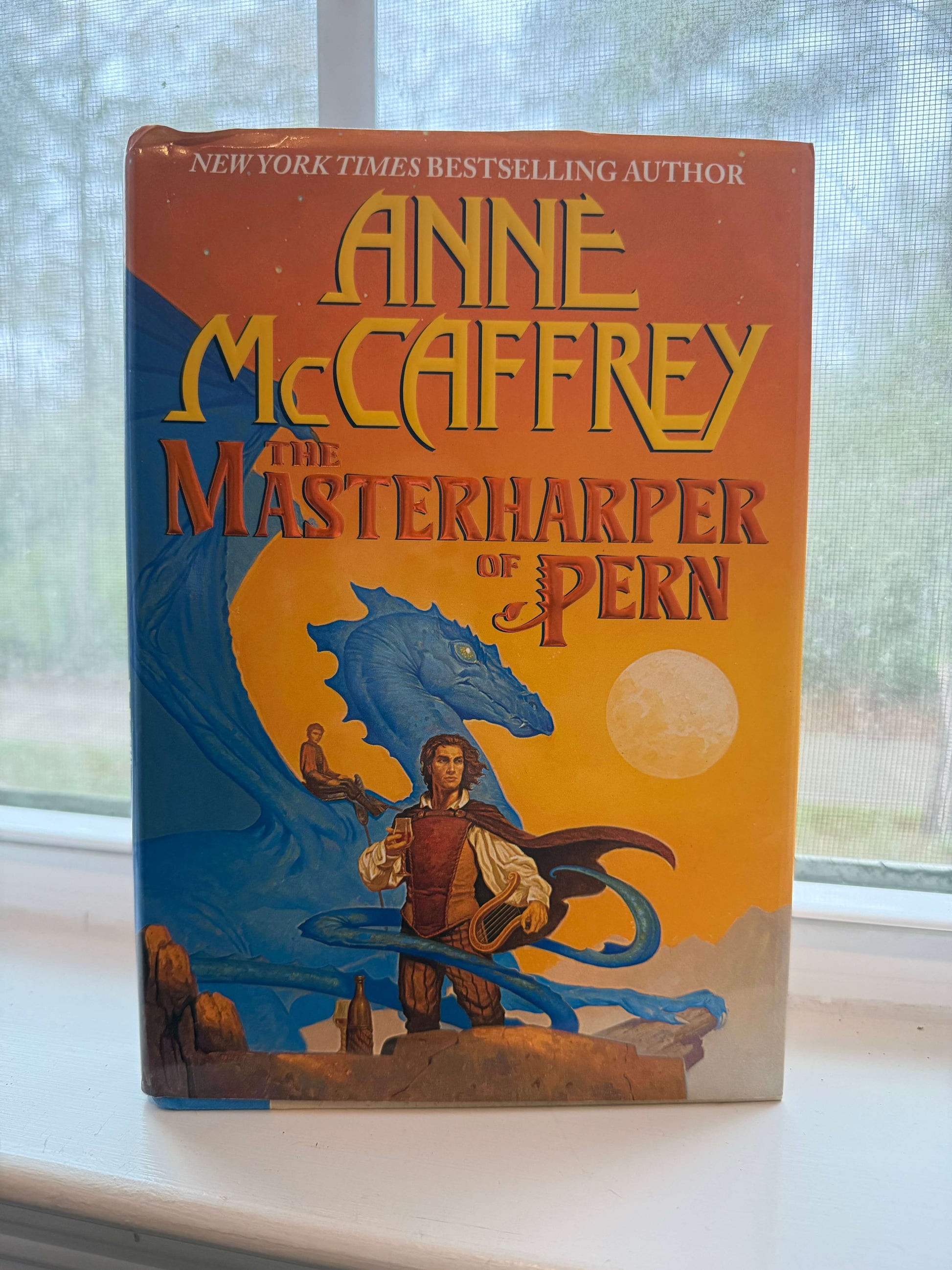 Book titled 'The Masterharper of Pern' by Anne McCaffrey on a windowsill.