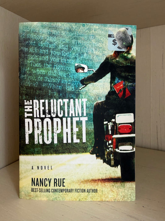 The book cover of 'The Reluctant Prophet' by Nancy Rue, featuring a stylized illustration of a person on a motorcycle with a dollar sign for a helmet, set against a textured teal background with text overlays.
