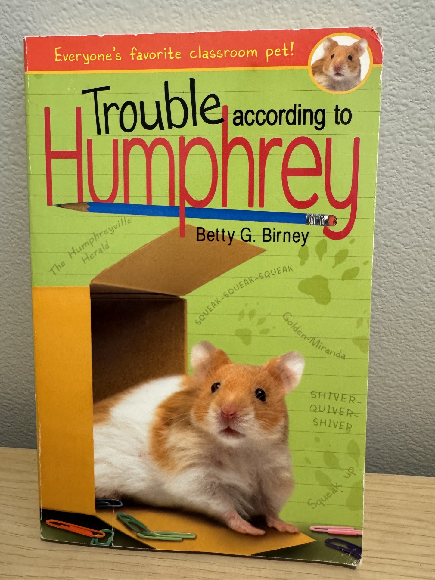 The front cover of the book 'Trouble according to Humphrey' by Betty G. Birney, featuring a hamster in a cardboard box on a green background with red and black title text.