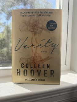 Book titled 'Verity' by Colleen Hoover on a windowsill with natural light.