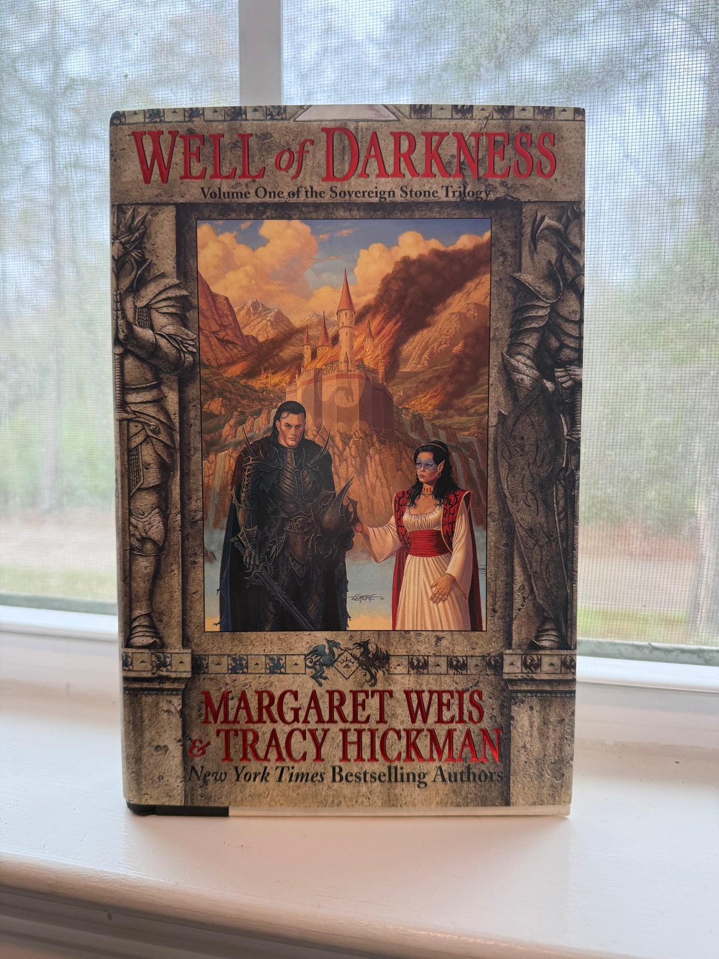Book titled 'Well of Darkness' by Margaret Weis and Tracy Hickman on a windowsill.