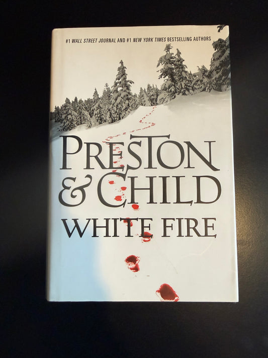 Book titled 'White Fire' by Preston & Child on a dark surface