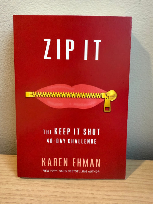 Book titled 'ZIP IT' by Karen Ehman with a red cover and gold zipper on a wooden surface.